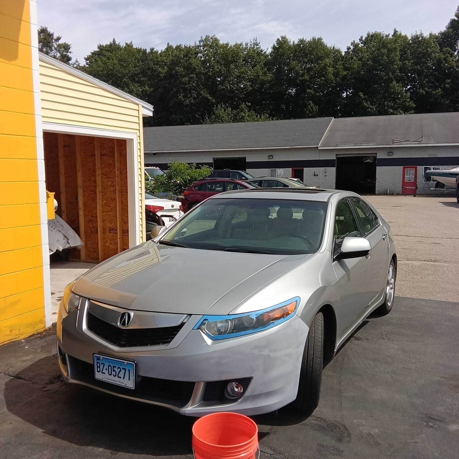 Silver Acura parked beside the yellow M & Son shop on Route 302 in Windham